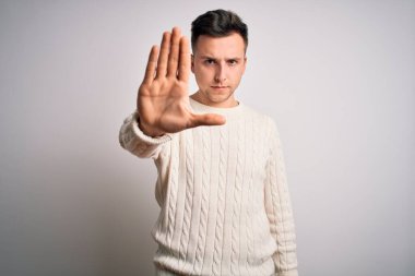 Beyaz tenli arka planda günlük kışlık süveter giyen yakışıklı beyaz bir adam avucunun içi gibi şarkı söylemeyi kesiyor. Yüzünde olumsuz ve ciddi bir jest olan uyarı ifadesi.