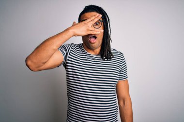 Genç, yakışıklı Afro-Amerikalı, rastalı, çizgili tişörtlü ve gözlüklü. Şok olmuş gözlerle yüzünü ve gözlerini kapayarak utanmış bir ifadeyle parmaklarının arasından bakıyor..