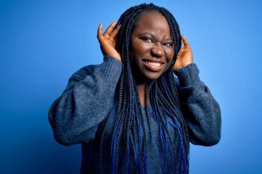 Mavi arka planda örgü ören Afro-Amerikan kadın. İki elini de kulak hareketi yaparken duymaya çalışıyor. Dedikoduya meraklı. İşitme problemi, sağır