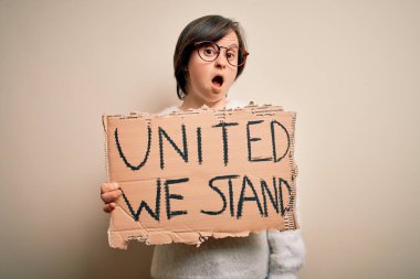 Down sendromlu genç kadın protesto pankartı tutuyor. Haklarımız var. Şok olmuş bir suratla korkuyoruz ve korku ifadesinden korkuyoruz.
