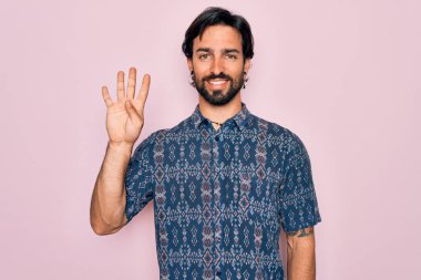 Pembe arka planda hippi tarzı giyinmiş genç, Latin asıllı bohem bir adam dört numarayı gösterirken kendine güvenen ve mutlu bir şekilde gülümsüyor..