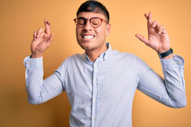 Sarı arka planda inek gözlüğü takan yakışıklı İspanyol iş adamı umut ve gözlerin kapalı bir şekilde gülümseyerek bana işaret etti. Şans ve batıl inanç..