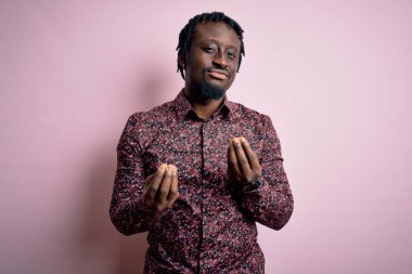 Genç, yakışıklı, Afro-Amerikalı bir adam pembe arka planda dikilmiş, para jesti yapıyor, maaşını istiyor, milyonerlik işi yapıyor.