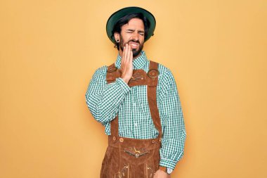 Almanya festivali için geleneksel Alman Ekim Festivali kıyafeti giyen genç yakışıklı adam diş ağrısı ya da diş ağrısı yüzünden ağıza acı dolu bir ifadeyle dokundu. Dişçi