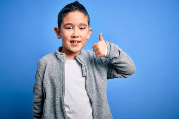 Niño Pequeño Con Sudadera Deportiva Sobre Fondo Azul Aislado Haciendo —  Fotos de Stock