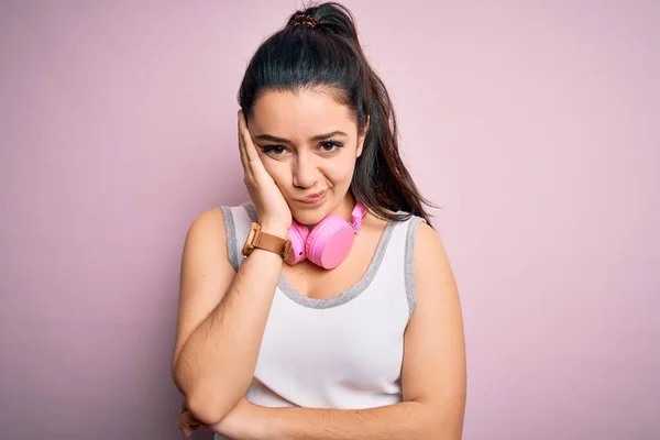 Jonge Brunette Fitness Vrouw Dragen Sportschool Koptelefoon Roze Geïsoleerde Achtergrond — Stockfoto