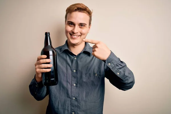 Junger Hübscher Rothaariger Mann Trinkt Eine Flasche Bier Auf Isoliertem — Stockfoto