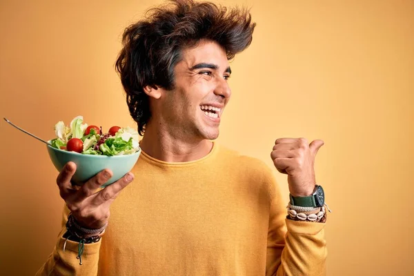 Young Handsome Man Holding Bowl Salad Standing Isolated Yellow Background — Stock Photo, Image