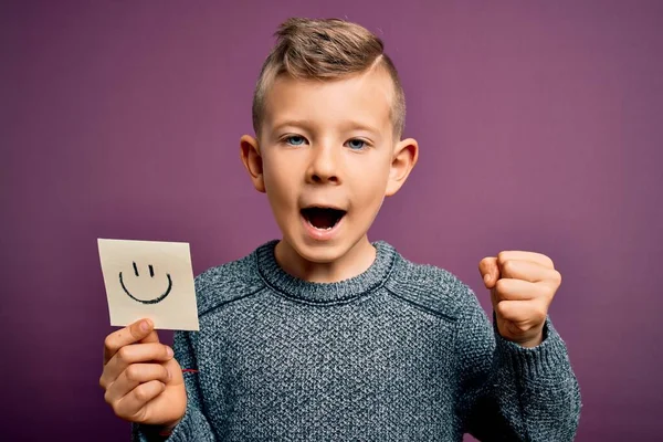 Küçük beyaz çocuk mutlu bir mesaj olarak gülen yüzünü gösteriyor. Gururla bağırıyor, zaferi ve başarıyı kutluyor. Çok heyecanlı, coşkulu bir duygu.