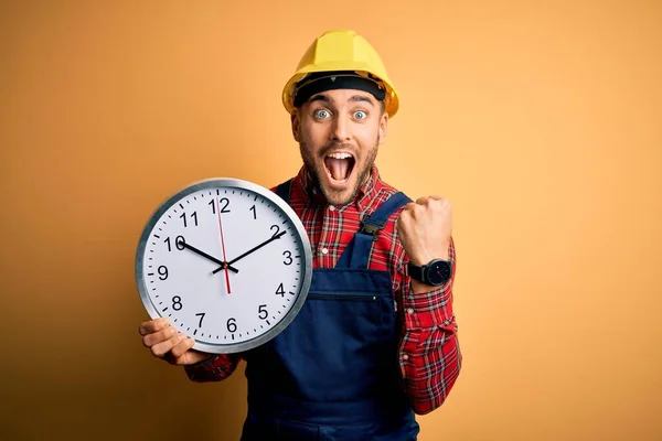Young Builder Man Wearing Safety Helmet Holding Big Clock Yellow — Stock Photo, Image