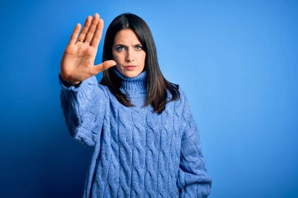青い目の若いブルネットの女性は手の手のひらで歌うのをやめるカジュアルなタートルネックセーターを着ています 顔に負と深刻なジェスチャーで警告式 — ストック写真
