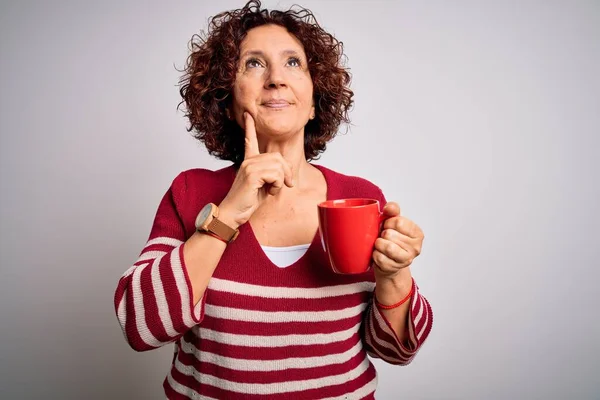 중년의 곱슬머리 여자가 격리되어 배경의 얼굴로 커피를 마시고 있습니다 — 스톡 사진