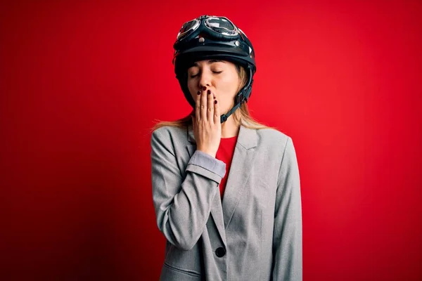 若い美しいブロンドのオートバイの女性は 赤い背景の上にオートバイのヘルメットを身に着けています 眠れないのか — ストック写真