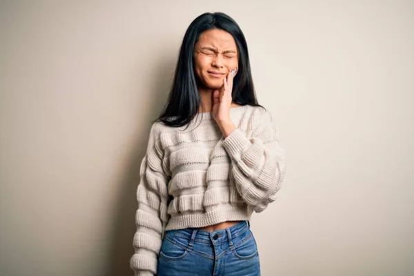 歯痛や歯の病気のために痛みを伴う表現で手で口に触れる孤立した白い背景の上にカジュアルなセーターを着て若い美しい中国の女性 歯医者 — ストック写真
