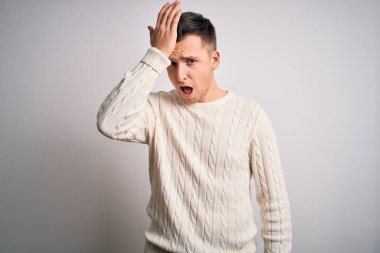 Beyaz soyutlanmış arka plan üzerine sıradan bir kazak giyen yakışıklı beyaz bir adam. Hatayla el ele tutuşurken şaşırdı. Hatayı hatırla. Unuttum, kötü hafıza konsepti.