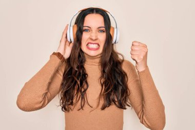 Mavi gözlü genç bir kadın müzik dinliyor ve dans ediyor. Kulaklıklar takıyor. Sinirli ve sinirli bir şekilde bağırıyor.