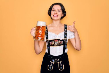 Mavi gözlü güzel Alman kadın geleneksel Ekim Festivali elbisesi giyiyor. Bira kavanozu içiyor. Kocaman gülümsüyor.