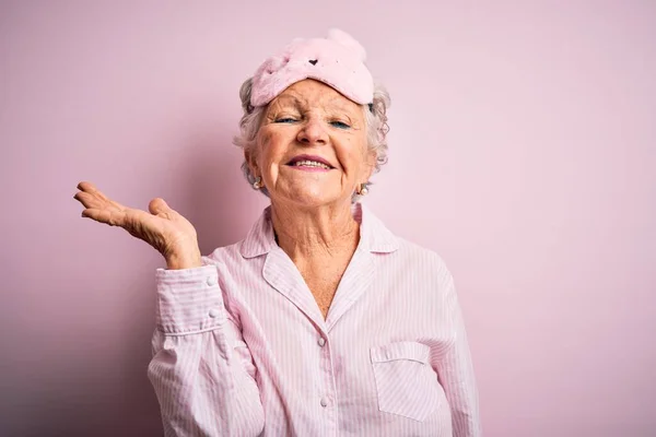 Starsza Piękna Kobieta Masce Snu Piżamie Odizolowanym Różowym Tle Uśmiecha — Zdjęcie stockowe
