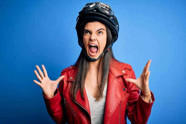 若い美しいブルネットのオートバイのヘルメットとジャケットを身に着けているオートバイの女性は狂気と怒りの叫びと積極的な表現と腕を上げて叫びました 欲求不満の概念 — ストック写真