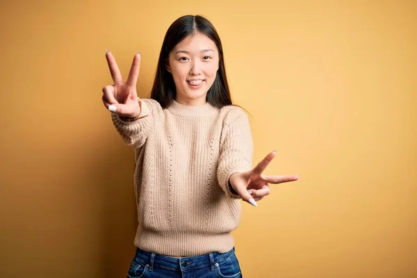 Młoda Piękna Azjatycka Kobieta Ubrana Luźny Sweter Żółtym Odizolowanym Tle — Zdjęcie stockowe