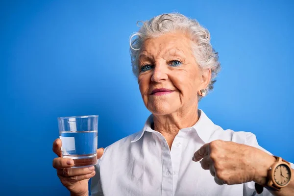 Senior Vacker Kvinna Dricka Glas Vatten Stående Över Isolerad Blå — Stockfoto