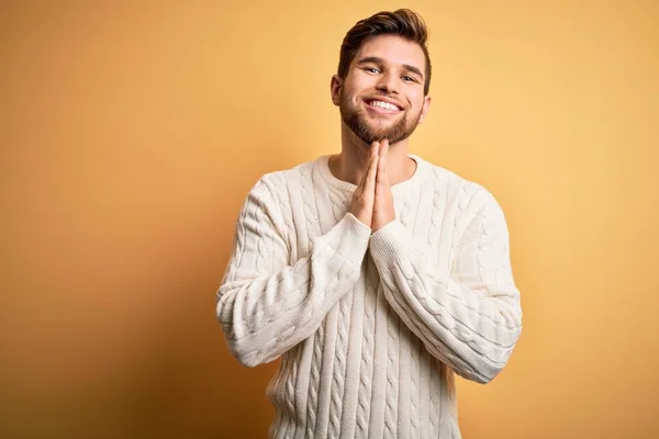 턱수염을 기르고 금발의 남자가 스웨터를 손으로 기도를 자신감에 미소를 있습니다 — 스톡 사진