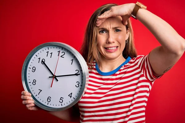 Junge Schöne Blonde Frau Mit Großer Uhr Vor Isoliertem Rotem — Stockfoto