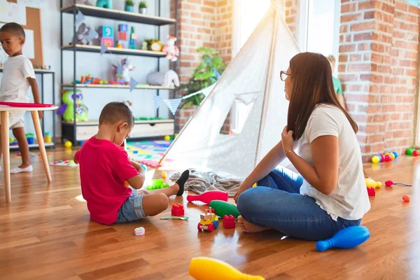 Junge Schöne Lehrerin Und Kleinkinder Spielen Kindergarten Mit Viel Spielzeug — Stockfoto