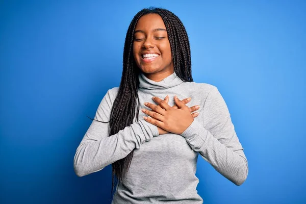 Mladá Afroameričanka Která Stojí Modrém Izolovaném Pozadí Nezávazným Rolákem Usmívá — Stock fotografie