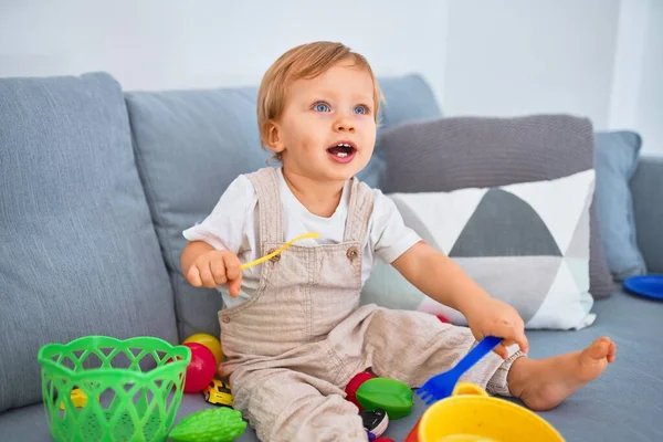 Adorable Blonde Toddler Smiling Happy Sitting Sofa Playing Plastic Meals — Stock Photo, Image