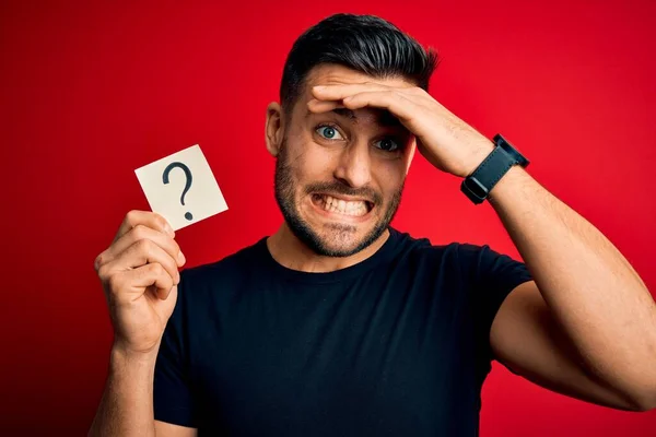 Jonge Knappe Man Met Papier Met Vraagteken Symbool Rode Achtergrond — Stockfoto