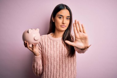 Genç, güzel, kumral bir kadın elinde kumbarayla emeklilik için para biriktiriyor. Açık elle dur işareti yapıyor. Ciddi ve kendinden emin bir ifadeyle, savunma jesti.