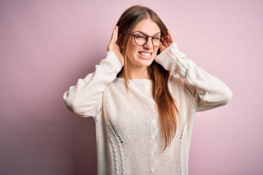 Genç, güzel, kızıl saçlı bir kadın pembe arka planda günlük süveter ve gözlük takıyor. İki elini de kulak hareketi yaparken duymaya çalışıyor. Dedikoduya meraklı. İşitme problemi, sağır