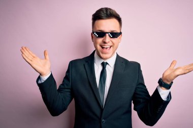 Genç, beyaz, beyaz, komik, cani gözlüklü bir iş adamı çılgın kutlamalar yapıyor ve kolları açık, gözleri açık heyecanla haykırarak başarıyı kutluyor. Kazanan konsept