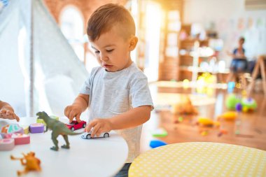 Sevimli bebek mutlu gülümsüyor. Anaokulunda bir sürü oyuncakla oynamak.