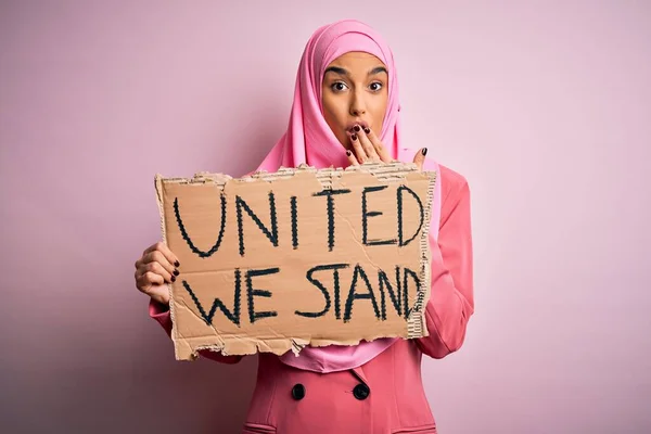 ピンクのイスラム教徒のヒジャーブを身に着けている若い活動家の女性私たちは 恐怖の表現 沈黙の中で怖がって 秘密の概念に恥でショックを受けた手で口をカバーメッセージをスタンド団結してバナーを保持 — ストック写真