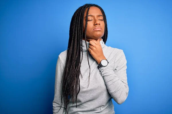 Young african american woman standing wearing casual turtleneck over blue isolated background Touching painful neck, sore throat for flu, clod and infection