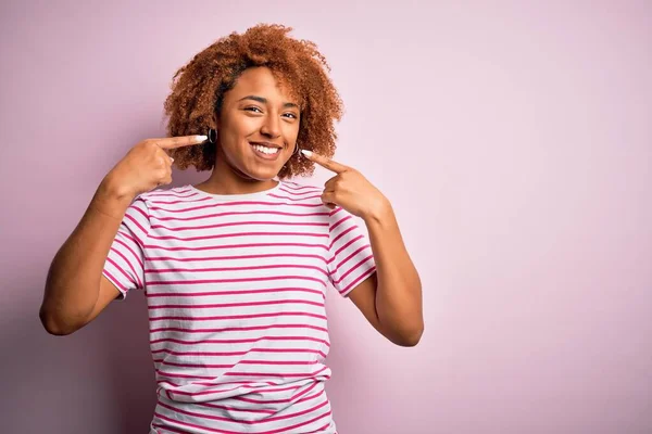 年轻美丽的非洲裔美国女人 卷曲的头发 穿着随意的条纹T恤 微笑着露出笑脸 用手指 牙齿和嘴指尖 牙齿健康概念 — 图库照片
