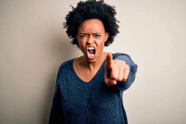 Young beautiful African American afro woman with curly hair wearing casual sweater pointing displeased and frustrated to the camera, angry and furious with you