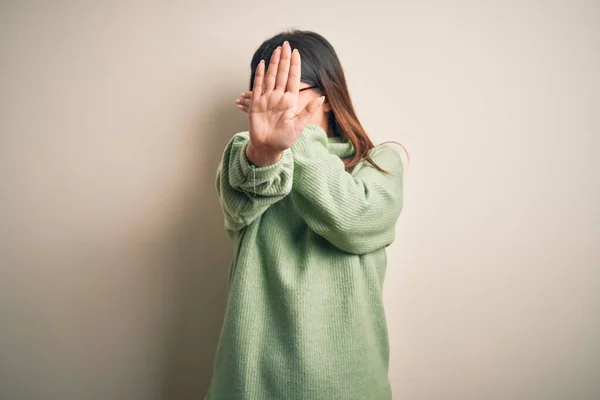 孤立した白い背景の上に立ち手で目を覆い悲しみと恐怖の表情でストップジェスチャーを行うカジュアルなセーターを着た若い美しい女性 恥ずかしいと否定的な概念 — ストック写真
