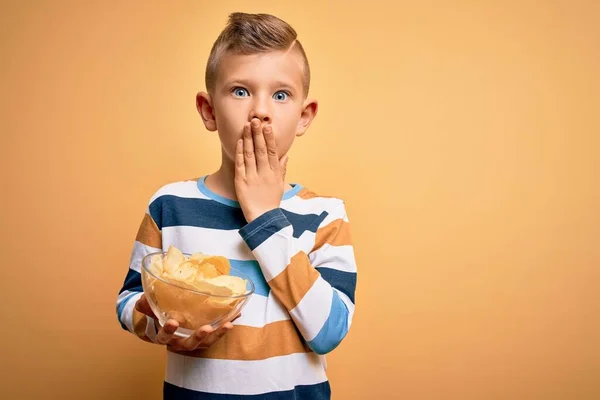 Młody Biały Dzieciak Nieogrzewane Chipsy Ziemniaczane Żółtym Tle Pokrywa Usta — Zdjęcie stockowe