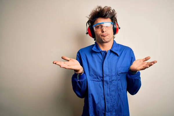 Young Constructor Man Wearing Uniform Earmuffs Isolated White Background Clueless — Stock Photo, Image
