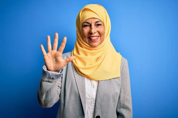 Middelbare Leeftijd Brunette Zakenvrouw Dragen Moslim Traditionele Hijab Blauwe Achtergrond — Stockfoto