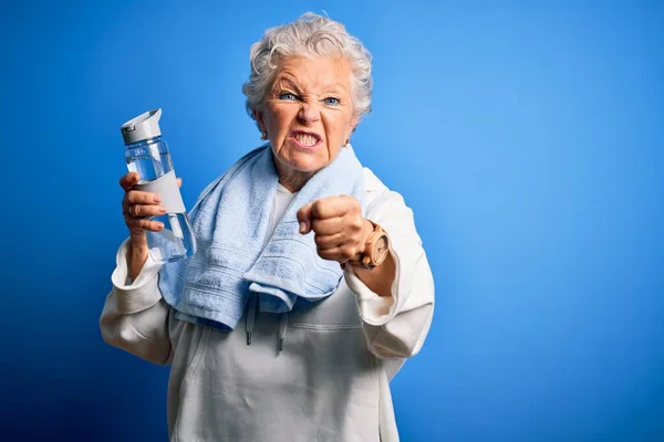 Senior Bela Mulher Desportiva Segurando Garrafa Água Sobre Fundo Azul — Fotografia de Stock