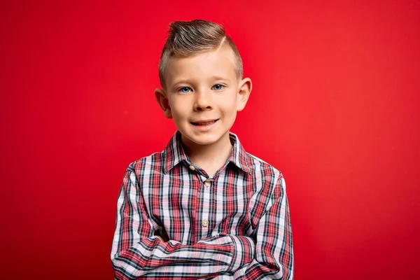年轻的高加索小孩 蓝眼睛 穿着华丽的衬衫站在红色的背景上 交叉着双臂看着相机 积极的人 — 图库照片