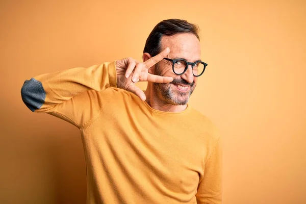 Człowiek Średnim Wieku Ubrany Luźny Sweter Okulary Odizolowanym Żółtym Tle — Zdjęcie stockowe