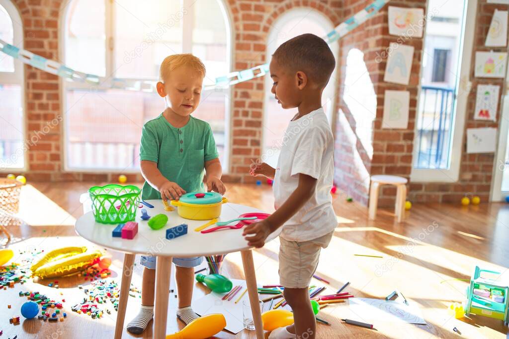 Adorable toddlers playing around lots of toys at kindergarten