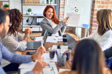 Birlikte çalışan bir grup işçi. Ofiste dizüstü bilgisayarla oturup belgeleri okumak.
