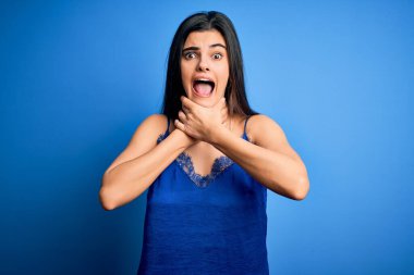 Zarif ve rahat mavi iç çamaşırı giyen genç, güzel esmer kadın bağırıyor ve boğuluyor çünkü acı verici bir şekilde boğuluyor. Sağlık problemi. Boğulma ve intihar konsepti.