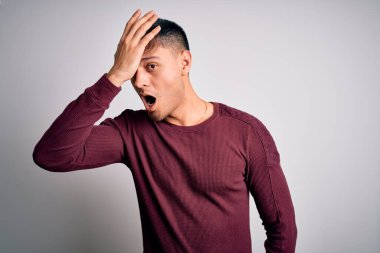 Beyaz soyutlanmış arka planda duran, gündelik tişörtlü, genç, yakışıklı İspanyol bir adam. Yanlışlıkla el ele tutuşarak şaşırmış. Hatayı hatırla. Unuttum, kötü hafıza konsepti.